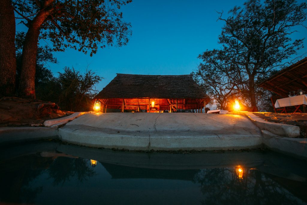 Luxury safari lodge and swimming pool at dusk