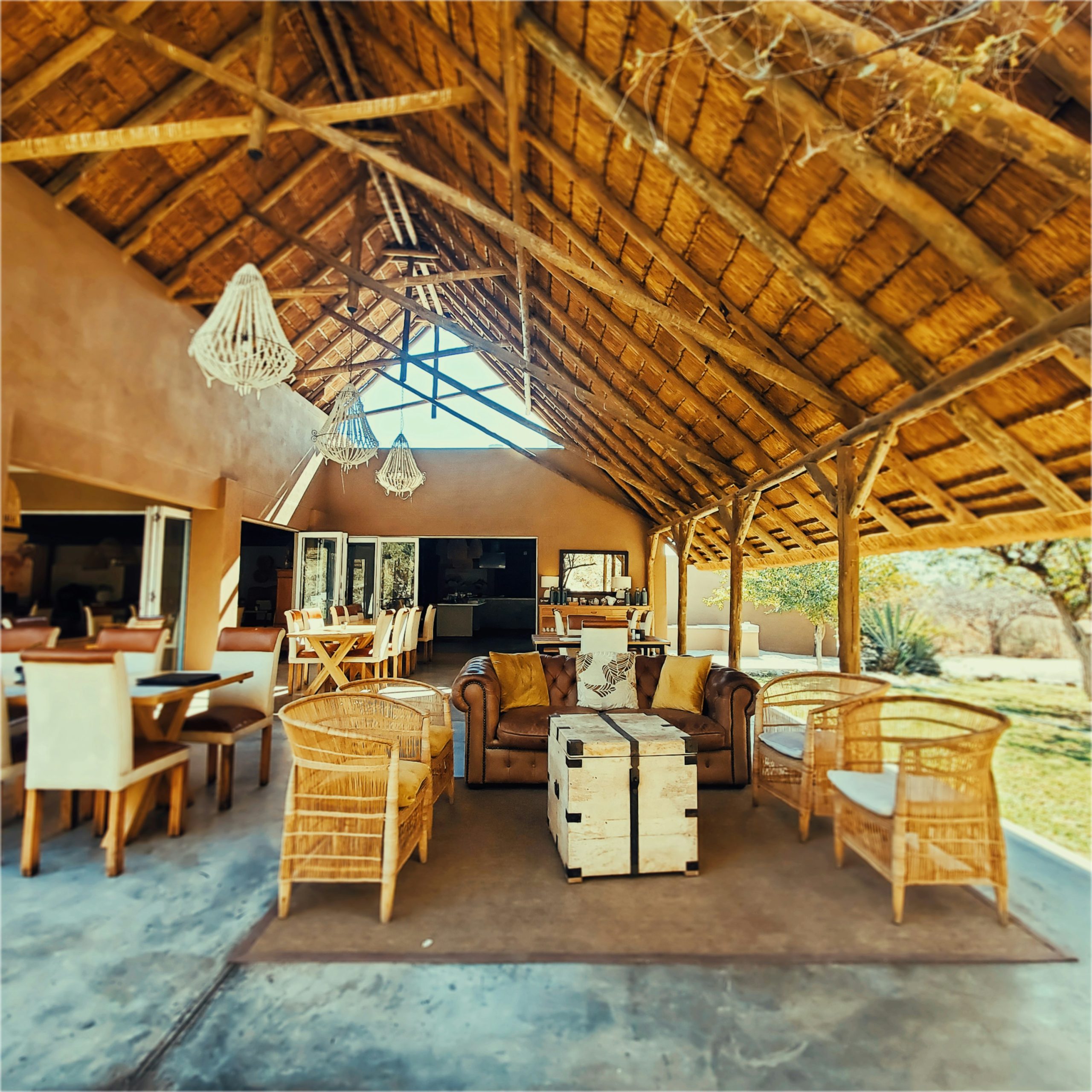 Open-air safari lodge lounge under a thatched roof